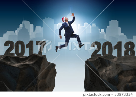 Businessman in santa hat jumping from 2017 to 2018 33873334
