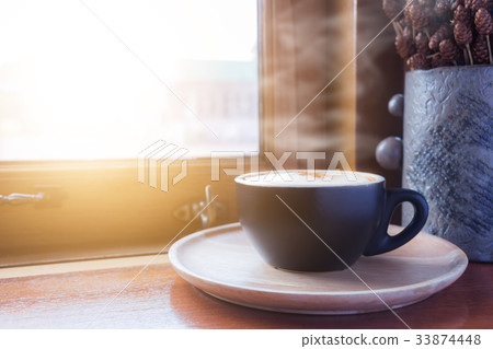Cup of coffee with steam on table in cafe Cup of coffee with steam on table in cafe 33874448