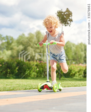 Little girl riding a scooter at the park 33878661