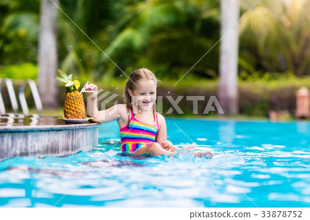 Child drinking juice in swimming pool bar 33878752