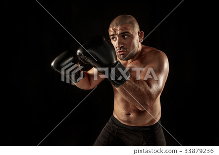 The young man kickboxing on black 33879236