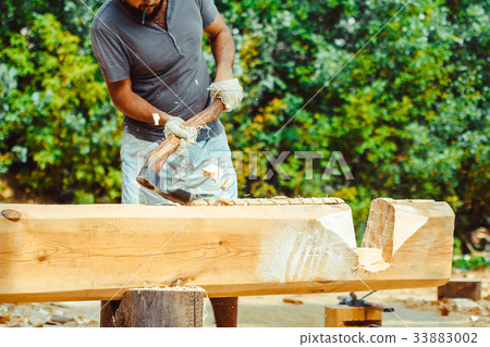 a man cuts a log 33883002