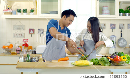 Young asian couple are teasing while cooking 33893360