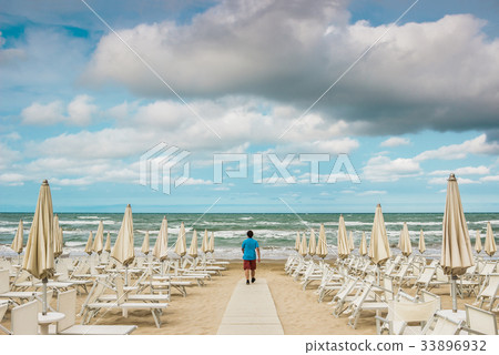 Lonely man is standing on the empty beach Lonely man is standing on the empty beach 33896932