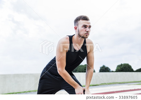 Athlete preparing for training on running track Athlete preparing for training on running track 33897605