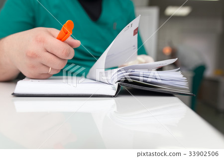 The doctor writes in a notebook at the clinic The doctor writes in a notebook at the clinic 33902506