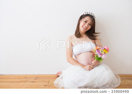 Pregnant woman in a dress with a bouquet 33908499