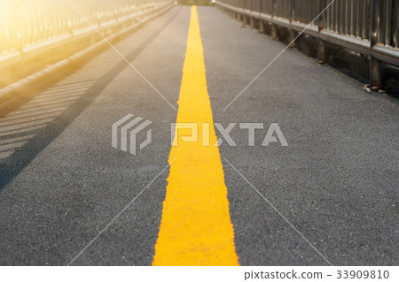 Asphalt perspective yellow road line, soft focus 33909810