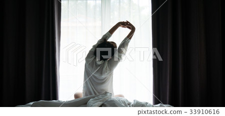 Asian women wake up from sleep are stretch herself Asian women wake up from sleep are stretch herself 33910616