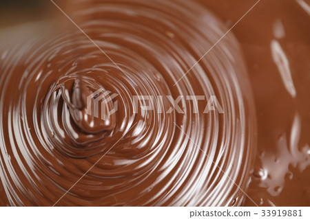 pouring melted premium dark chocolate from above pouring melted premium dark chocolate from above 33919881