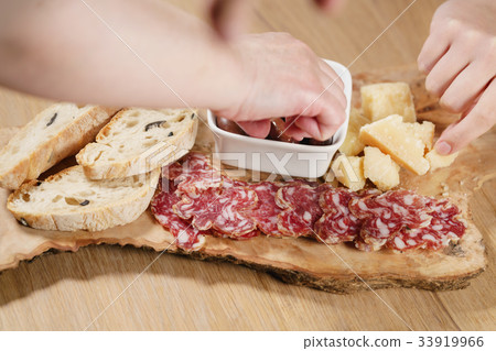 hands taking italian antipasti appetizers on table hands taking italian antipasti appetizers on table 33919966