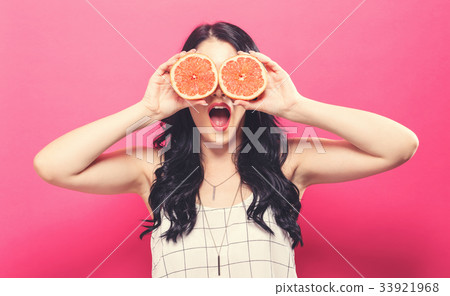 Happy young woman holding oranges Happy young woman holding oranges 33921968