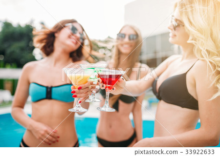 Sexy girls with coctails near the swimmimg pool 33922633