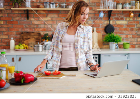 Cheerful woman cooking on modern kitchen Cheerful woman cooking on modern kitchen 33922823
