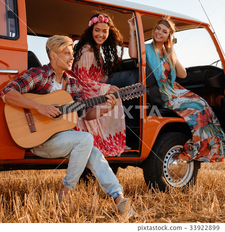 Hippie friends with guitar on a road trip 33922899