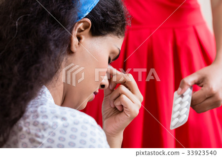 Woman giving medication against headache Woman giving medication against headache 33923540