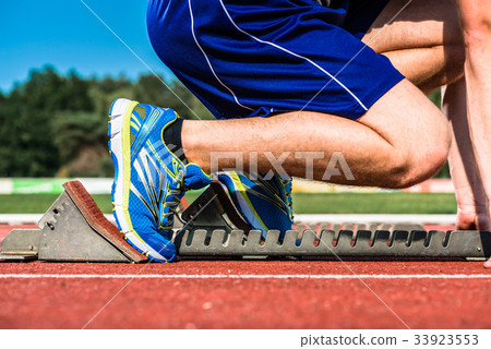 Runner before start signal on starting block of Runner before start signal on starting block of 33923553