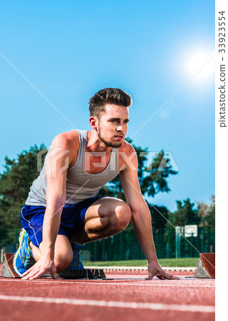 Track and field sprinter on starting point at 33923554