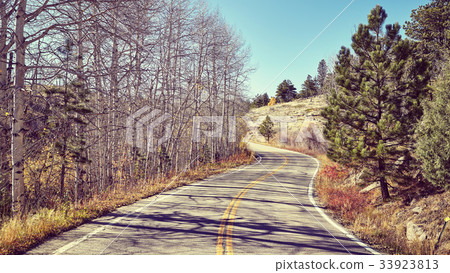 Vintage toned picture of a scenic road in autumn. 33923813