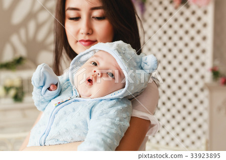 Loving Asian Mother Holding Baby Son At Home 33923895
