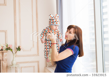 Young mother holding her little baby 33923915