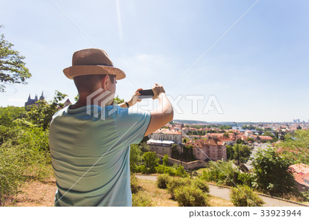 Back view of a young man tourist taking photo with Back view of a young man tourist taking photo with 33923944