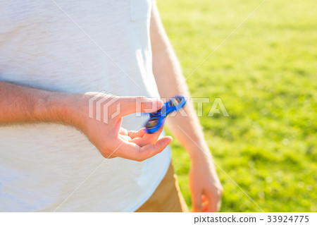 Man hand holding popular fidget spinner toy, 33924775