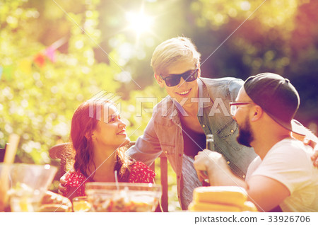 happy friends having dinner at summer garden party 33926706