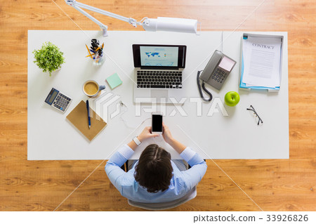 businesswoman with laptop and smartphone at office businesswoman with laptop and smartphone at office 33926826