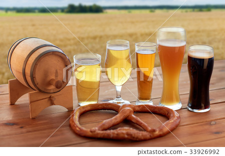 beer glasses, barrel and pretzel over cereal field beer glasses, barrel and pretzel over cereal field 33926992