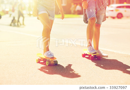teenage couple riding skateboards on city street teenage couple riding skateboards on city street 33927097