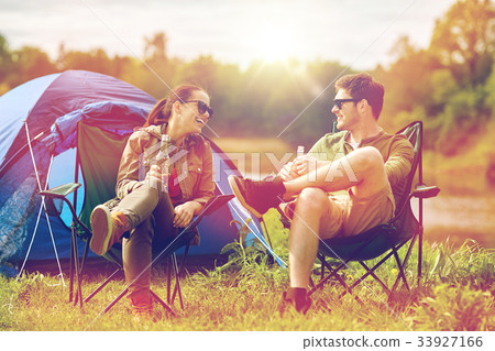 happy couple drinking beer at campsite tent happy couple drinking beer at campsite tent 33927166
