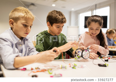happy children building robots at robotics school 33927277