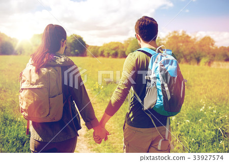 happy couple with backpacks hiking outdoors happy couple with backpacks hiking outdoors 33927574