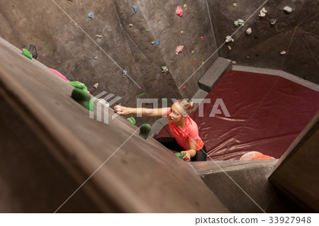 young woman exercising at indoor climbing gym young woman exercising at indoor climbing gym 33927948