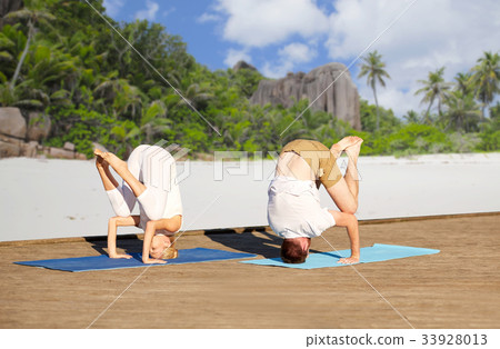 couple making yoga over tropical beach couple making yoga over tropical beach 33928013