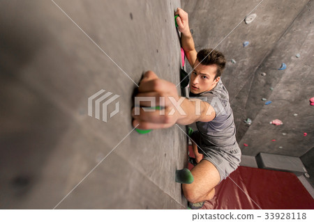 young man exercising at indoor climbing gym 33928118