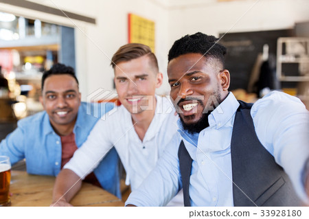 friends taking selfie and drinking beer at bar friends taking selfie and drinking beer at bar 33928180