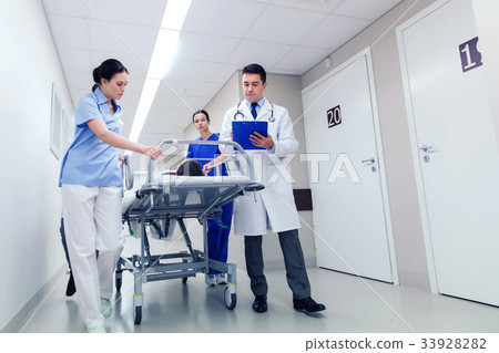 medics with woman on hospital gurney at emergency 33928282