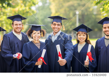 happy students in mortar boards with diplomas 33928400