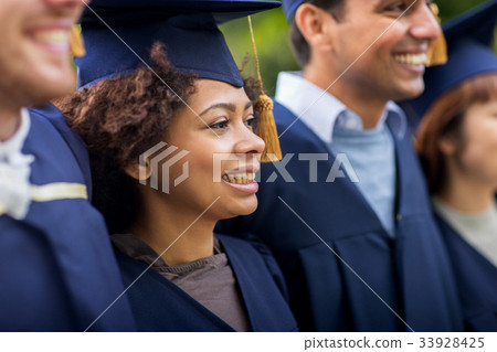 happy students or bachelors in mortar boards 33928425