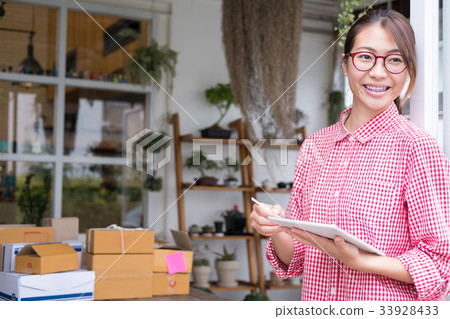 start up small business owner working with digital tablet at workplace. freelance woman entrepreneur SME seller check product order to prepare for delivery to customers. Online selling, internet marketing, e-commerce, shipping concept start up small business owner working with digital tablet at workplace. freelance woman entrepreneur SME seller check product order to prepare for delivery to customers. Online selling, internet marketing, e-commerce, shipping concept 33928433