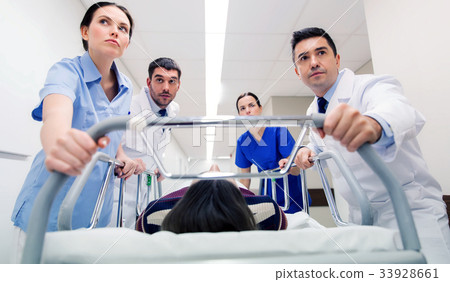 medics with woman on hospital gurney at emergency medics with woman on hospital gurney at emergency 33928661
