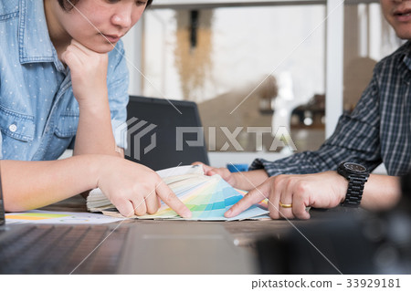 graphic or interior designer choosing a colour from color swatch sampler or catalogue palette guide 33929181