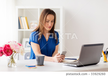 woman with smartphone and laptop at office woman with smartphone and laptop at office 33929260