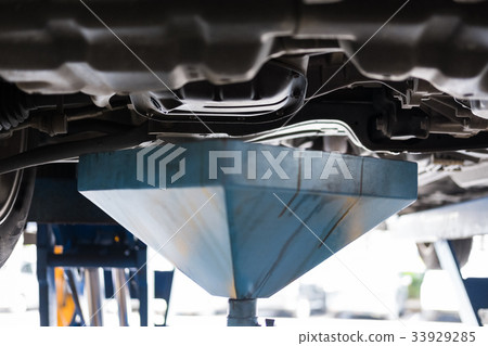 vehicle lift up by hydraulic for engine oil change and transmission inspection. changing motor oil in automobile repair service. maintenance & checkup in car workshop. 33929285
