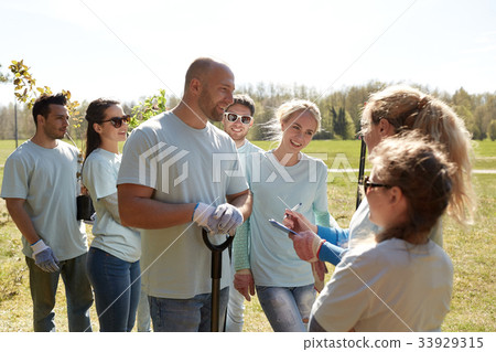 group of volunteers with tree seedlings in park 33929315