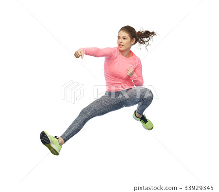 happy sporty young woman jumping in fighting pose 33929345