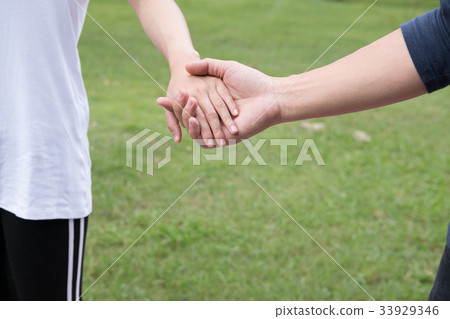 happy young couple holding hands in garden. Boyfriend and girlfriend walking in public park. Love, romance and relationship concept happy young couple holding hands in garden. Boyfriend and girlfriend walking in public park. Love, romance and relationship concept 33929346