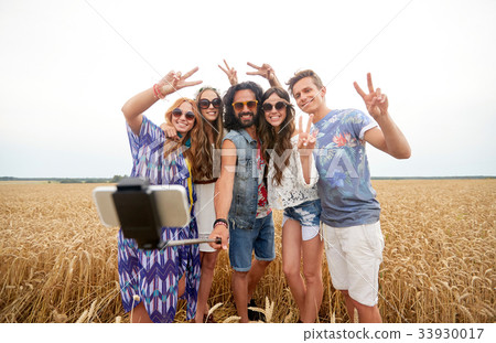 hippie friends with smartphone on selfie stick hippie friends with smartphone on selfie stick 33930017